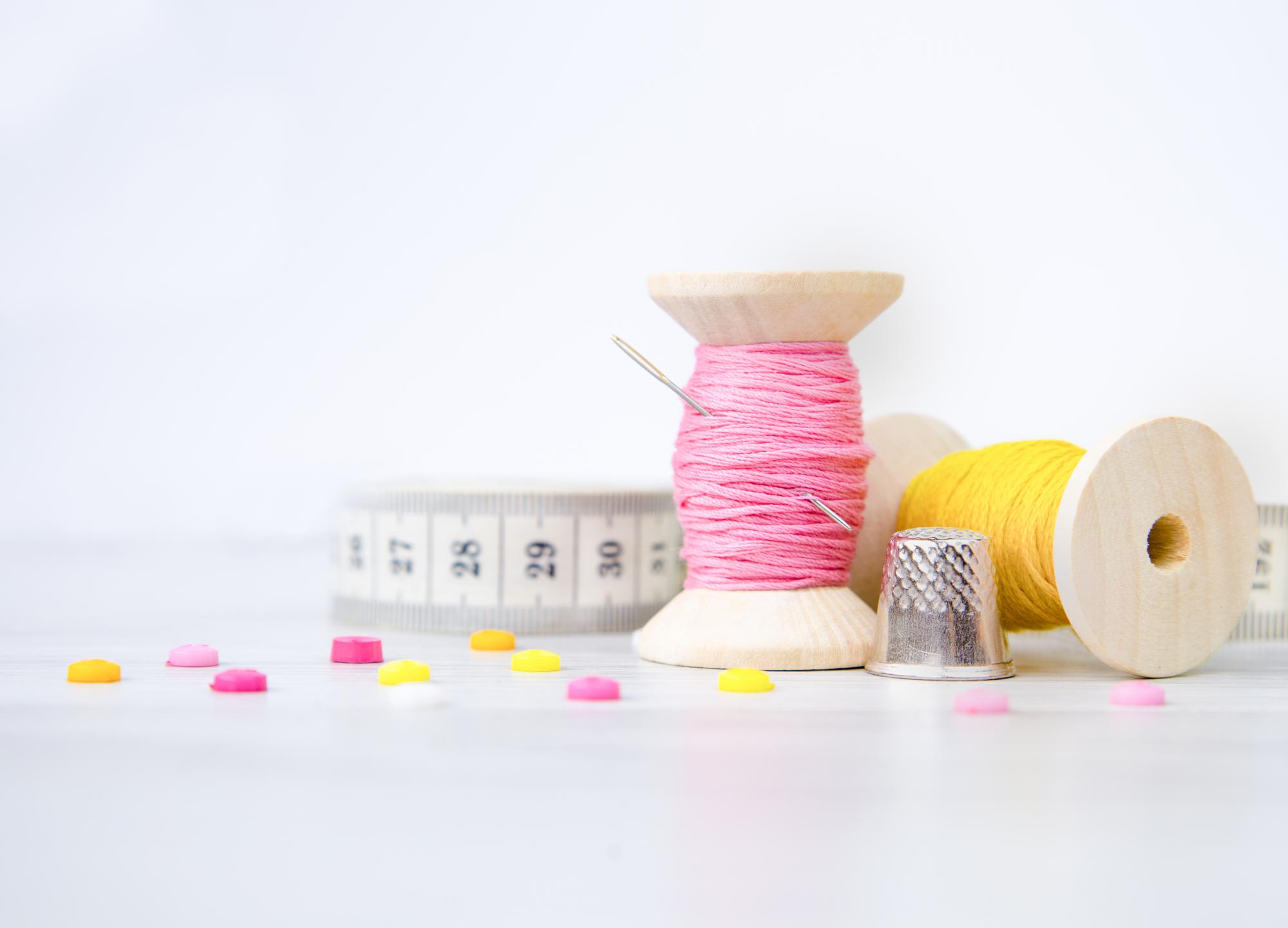 stół z narzędziami do haftu i przewiniętymi nićmi